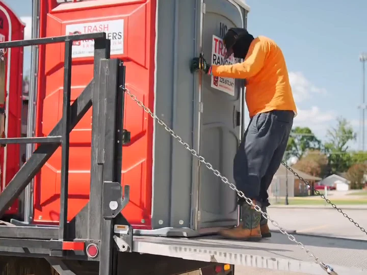 Trash Rangers crew member working a portable toilet on the truck lift gate during setup